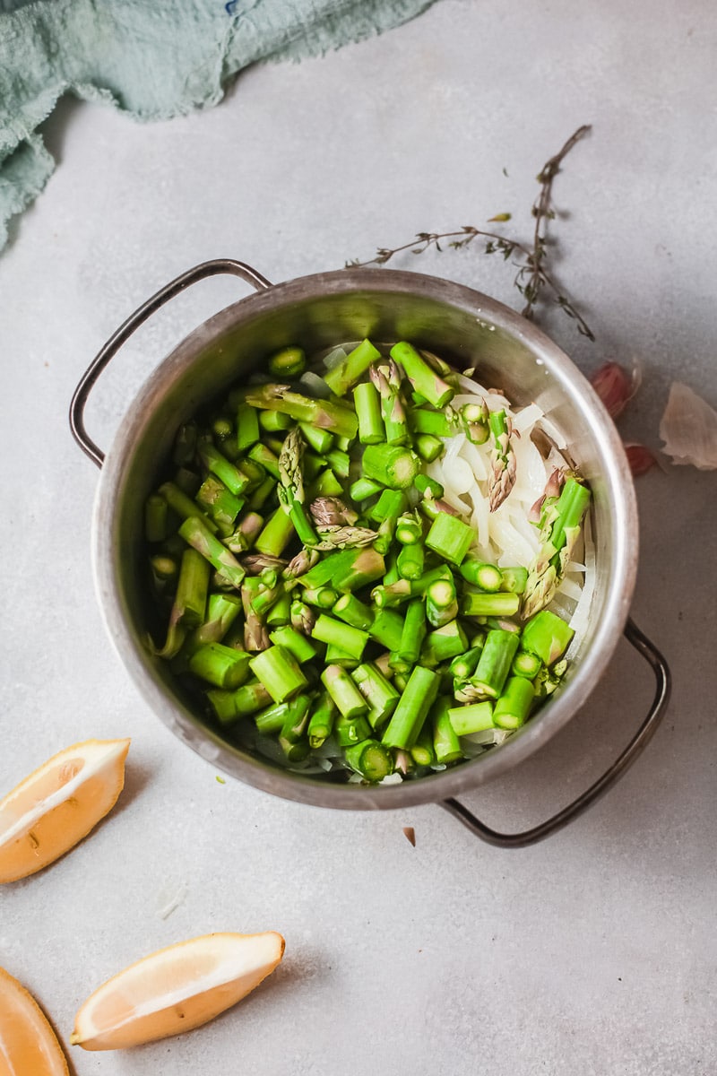 chopped asparagus and onions in a cooking pot