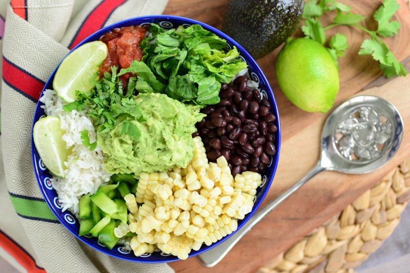 vegan burrito bowl being served with avocado