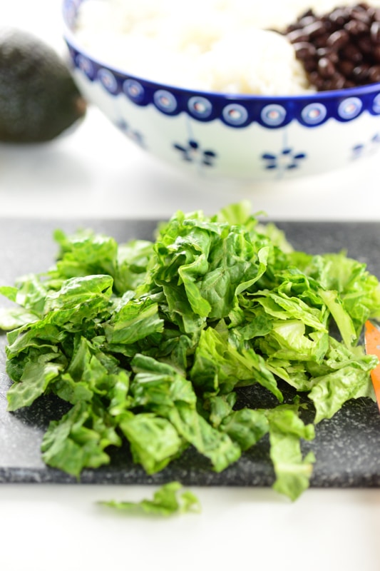 lettuce being cut for vegan burrito bowls