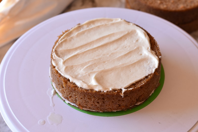 bottom layer of cake topped with vegan cream cheese frosting