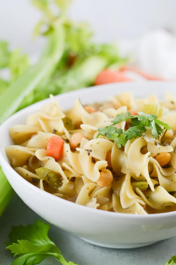 vegan chicken noodle soup being served in a white bowl