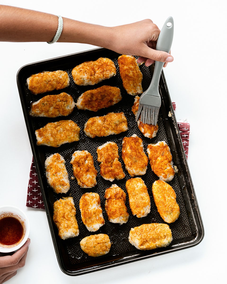 brushing mixture onto cauliflower nuggets