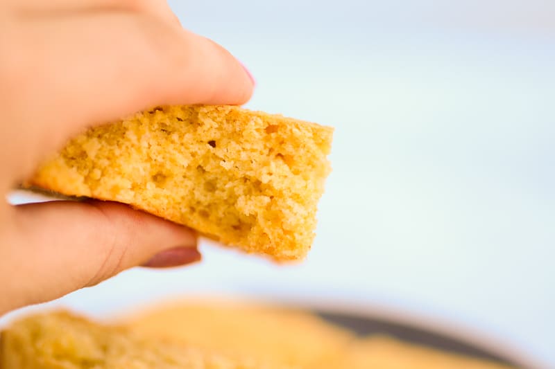 vegan cornbread in a hand ready to eat