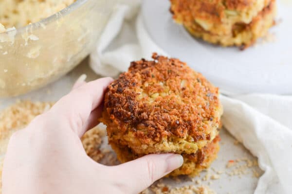 hand reaching for vegan crab cakes