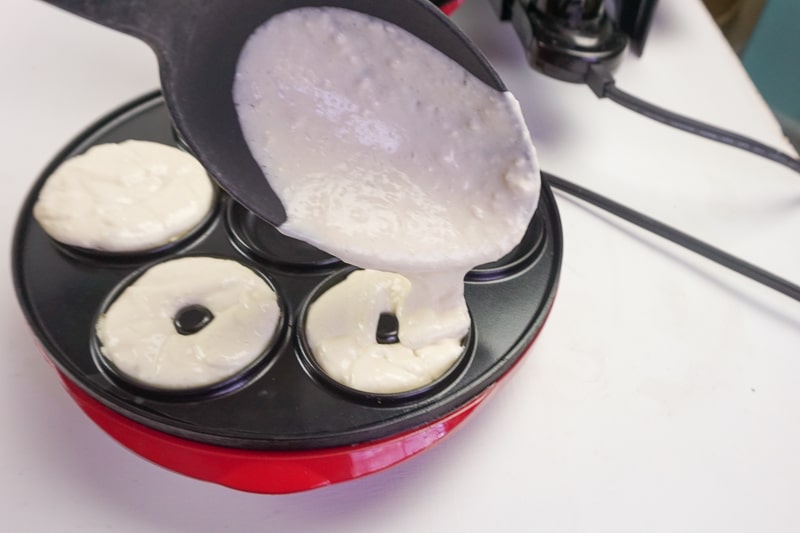 filling the donut maker with vegan donut batter