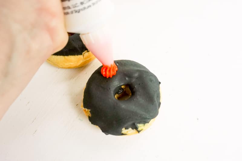 decorating vegan donuts with orange icing