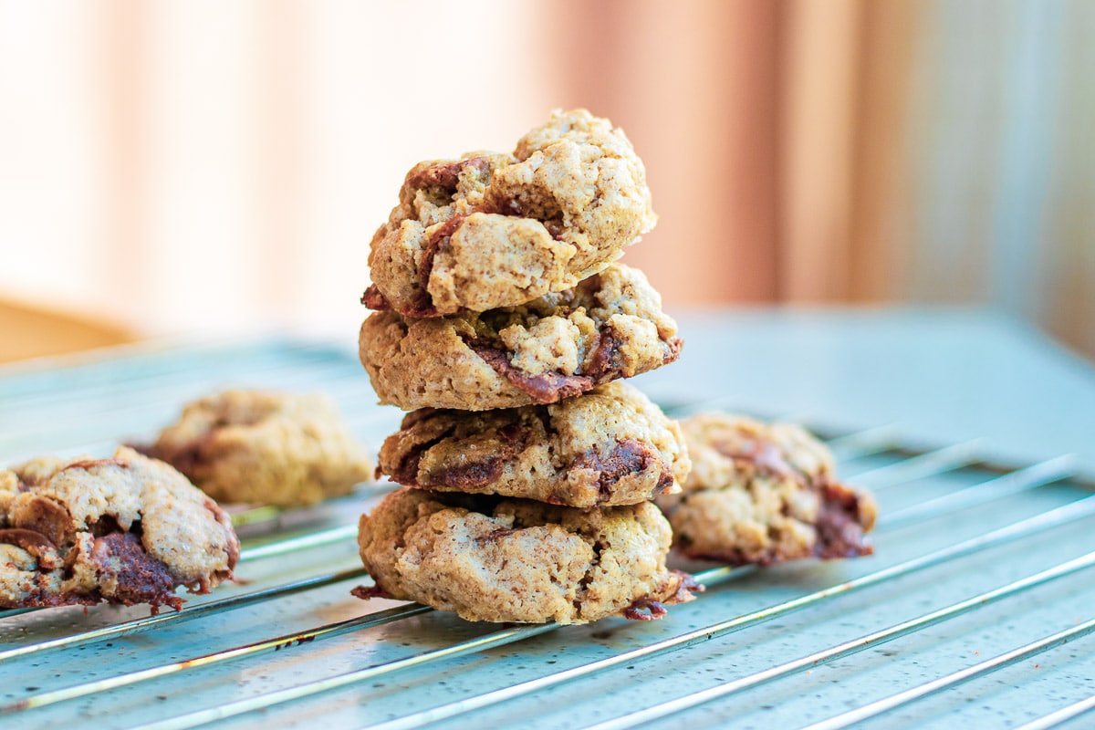 vegan gluten free chocolate chip cookies stacked on a cooling tray