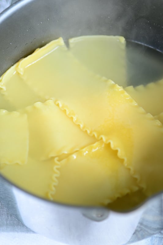 vegan lasagna noodles being cooked in large pot