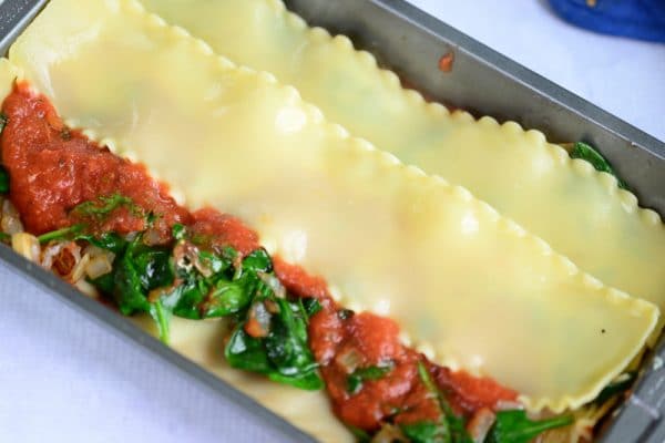 assembling vegan lasagna in a baking pan