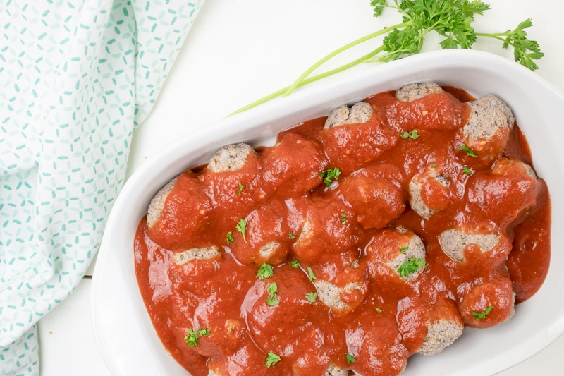 vegan meatless meatballs and tomato sauce in a baking dish