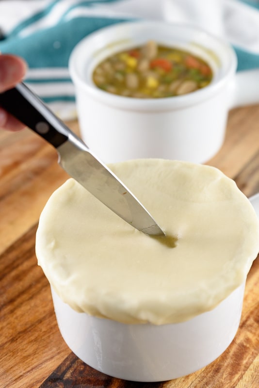 cutting a slit in the pastry crust for pot pies to bake