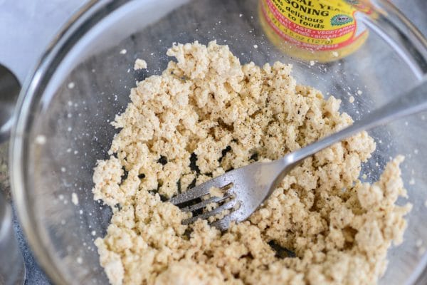 mashing tofu with a fork for vegan ricotta cheese