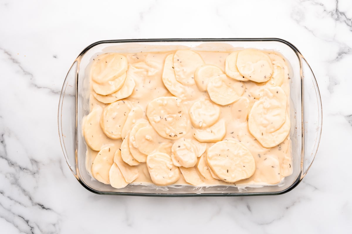 mixing the vegan cheese sauce and the potatoes together 