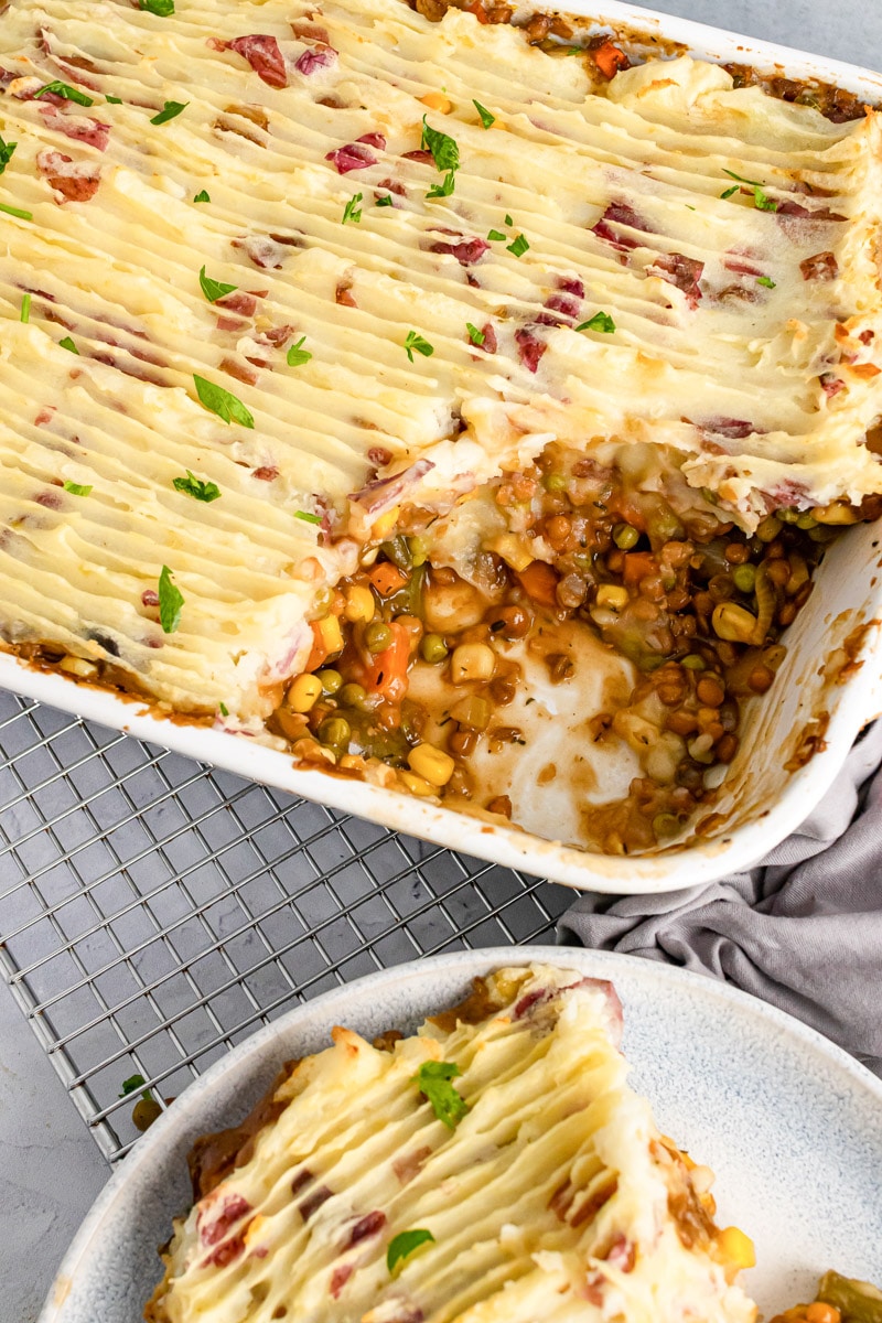 slice of vegan shepherd's pie on a plate next to casserole