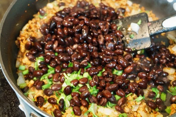 adding black beans to the chili cheese dip