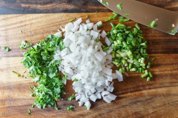 chopping veggies for vegetarian chili cheese dip