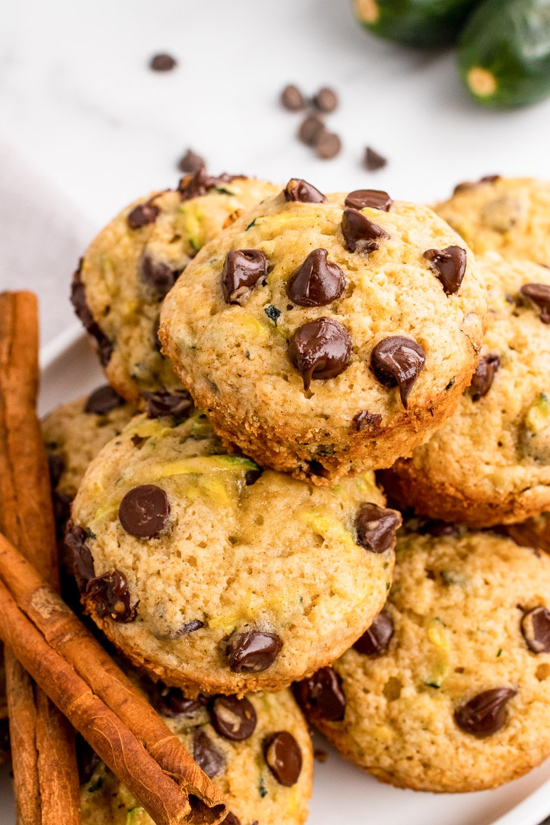 close up stack of zucchini chocolate chip muffins and cinnamon sticks