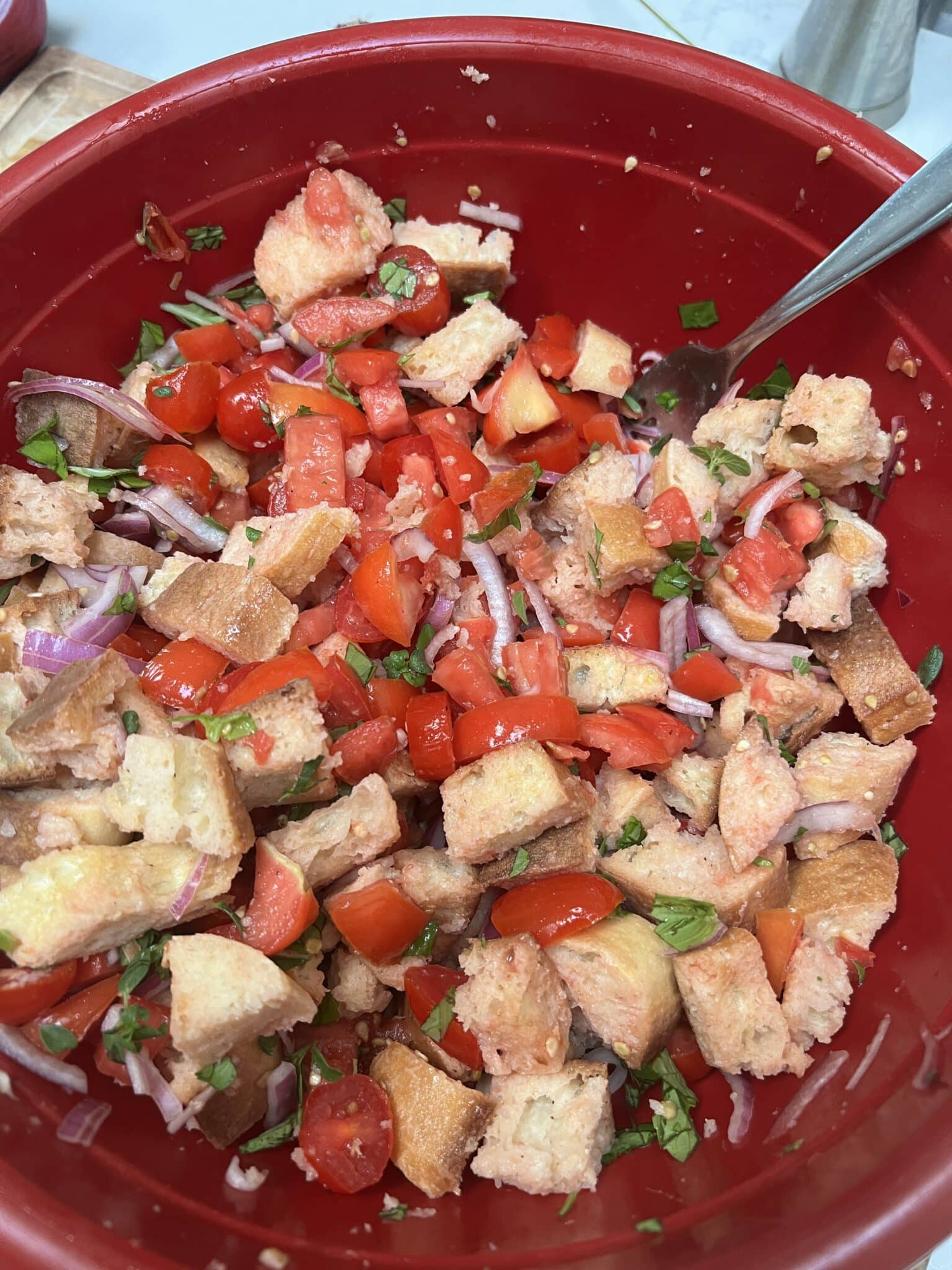 mixing the ingredients for panzanella salad