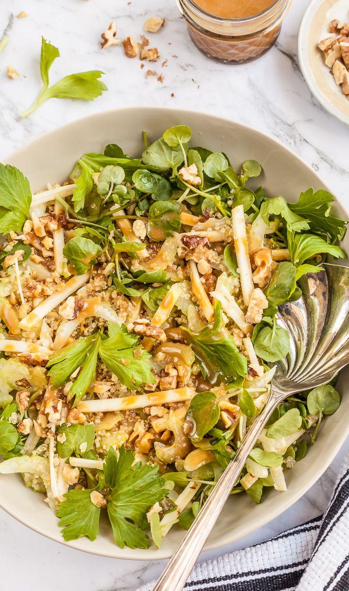 Overhead shot of celery apple walnut salad with honey miso dressing and a serving spoon