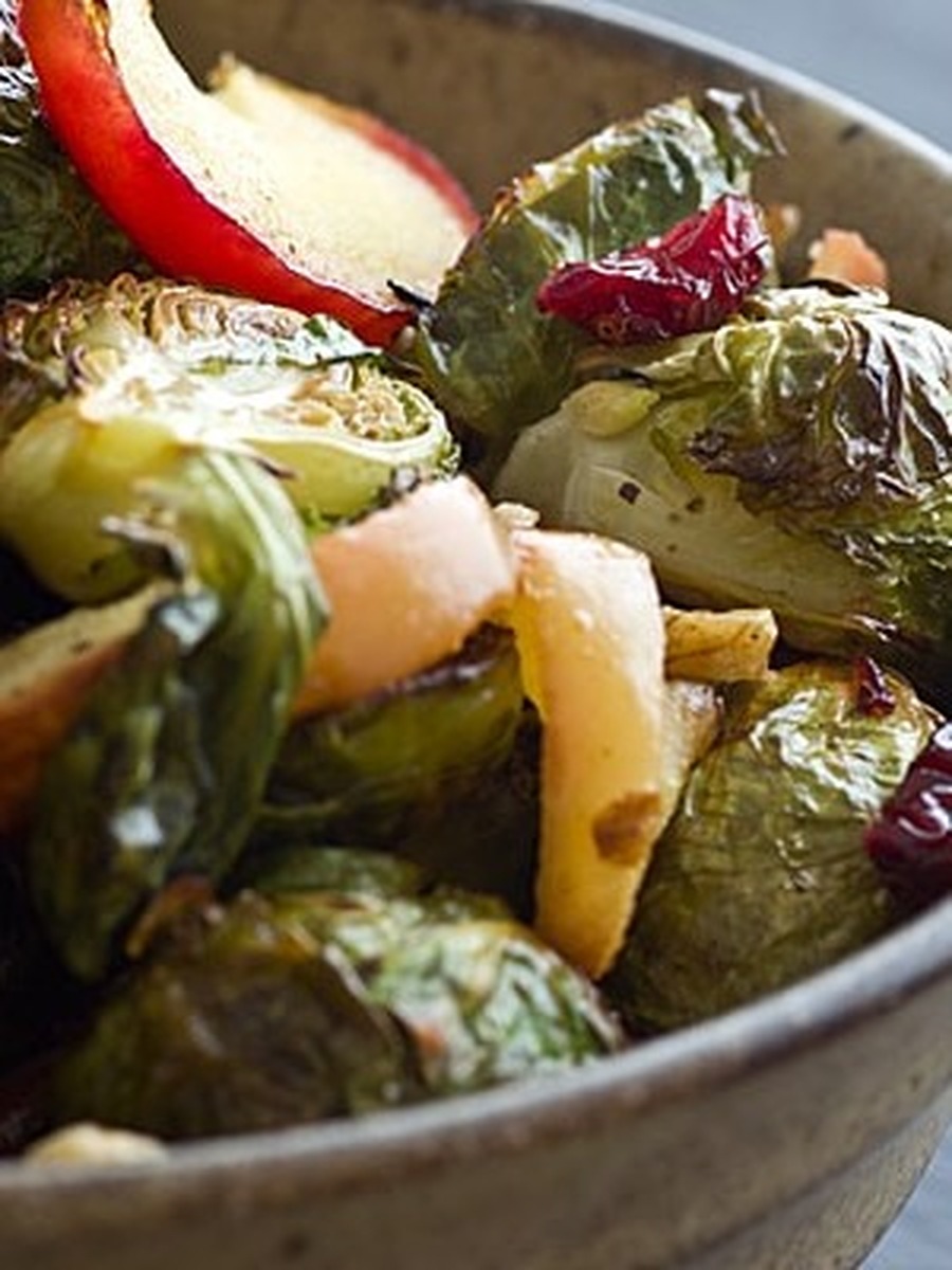 Close-up of roasted brussels sprouts, apple slices, and dried cranberries in a bowl