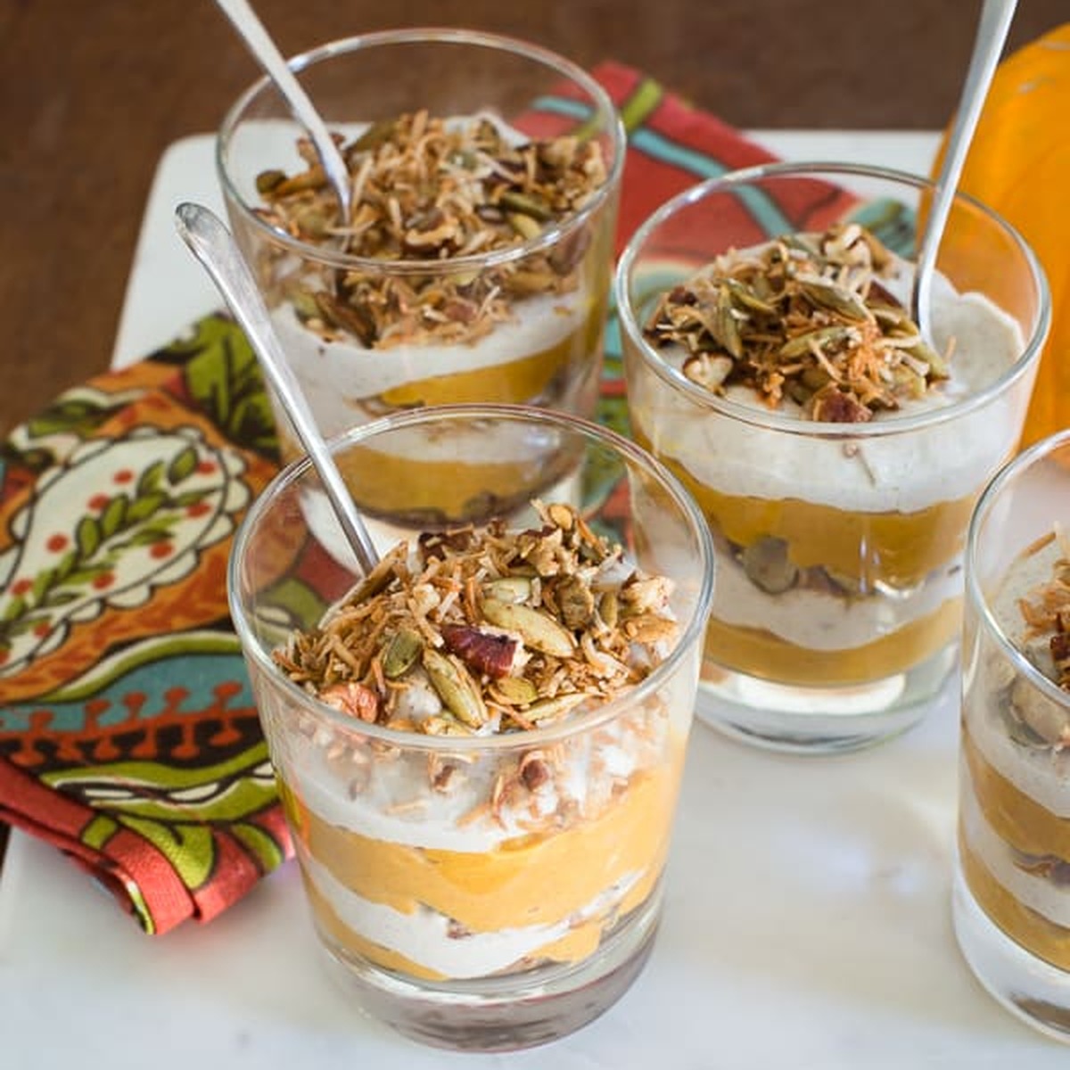 Maple pumpkin parfaits layered with cashew coconut cream and topped with a crunchy pecan and pumpkin seed crumble