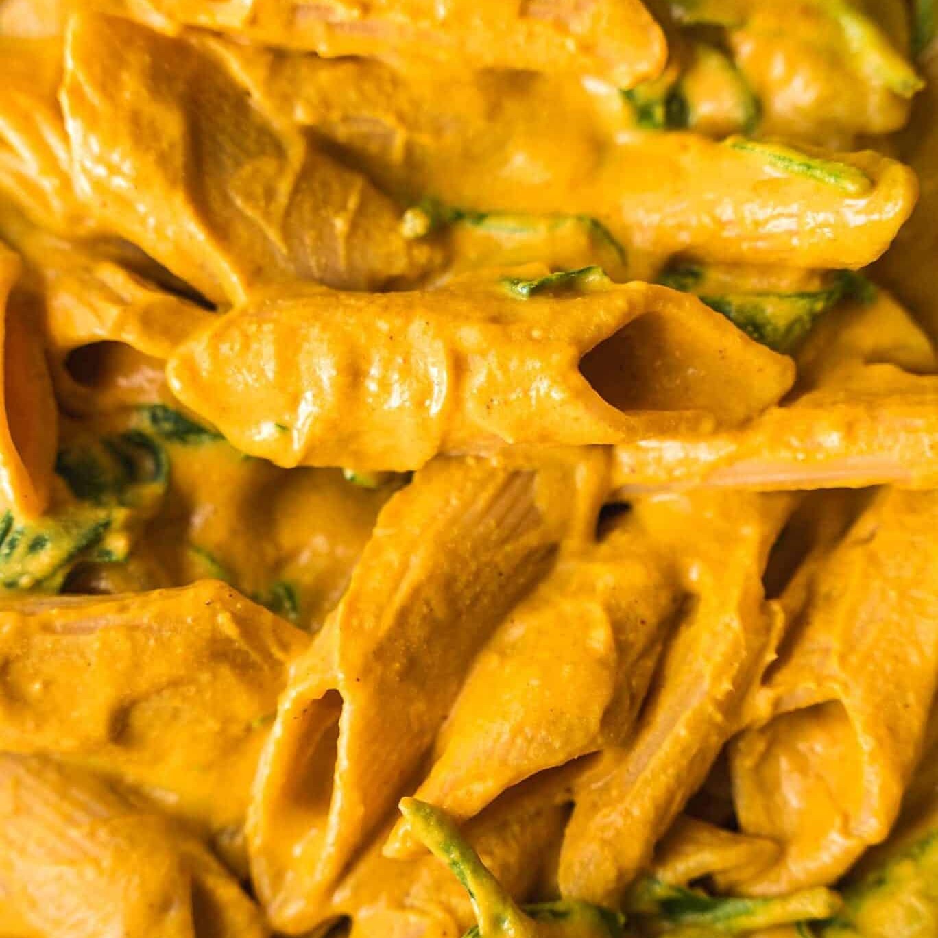 Close-up of creamy vegan butternut squash mac and cheese with penne and spinach