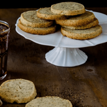 Chai shortbread cookies stacked on a white cake stand