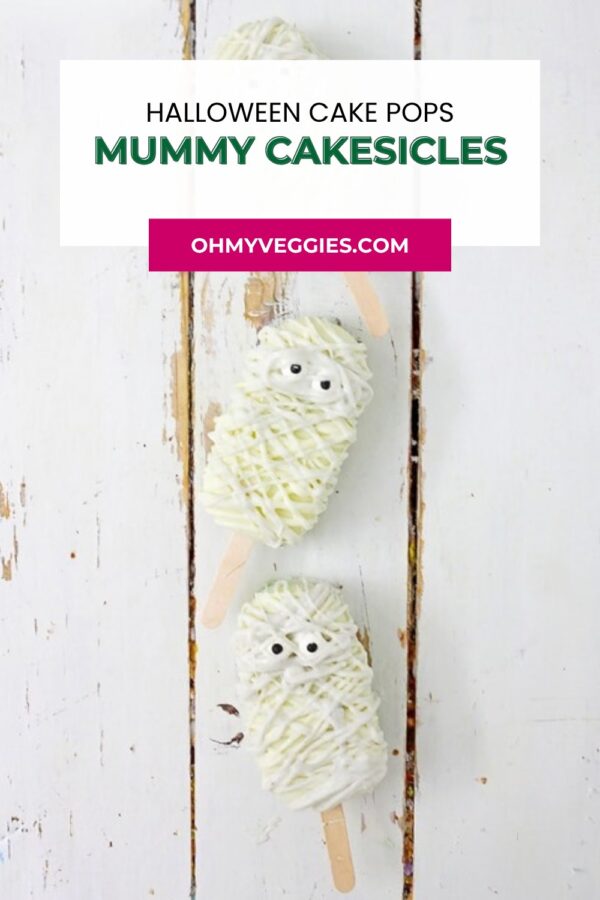 Mummy cakesicles lined up on a white wooden board, with text overlay for Pinterest