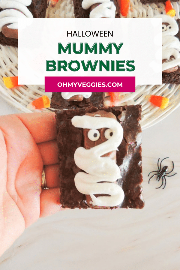 Halloween mummy brownies Pinterest graphic with a hand holding a mummy brownie