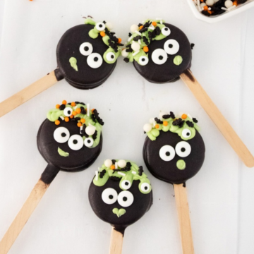 Halloween Oreo Pops decorated as witch cauldrons with candy eyes and green bubbles