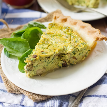Slice of vegan tofu quiche with spinach on a white plate