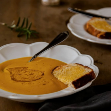 Lazy roasted pumpkin soup with no cream in a white bowl with a slice of toast