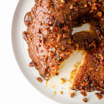 Maple pecan bundt cake with a slice removed on a white plate