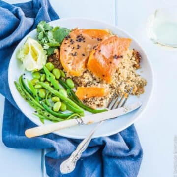 Miso glazed pumpkin with quinoa, edamame and snow peas on a white plate