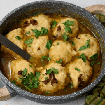 One-pot vegan mushroom dumpling soup in a grey pot garnished with fresh parsley