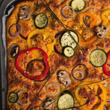 Pumpkin focaccia bread topped with bell peppers, zucchini, mushrooms and red onion