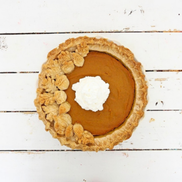 Overhead view of a pumpkin pie with a homemade crust decorated with pastry leaves