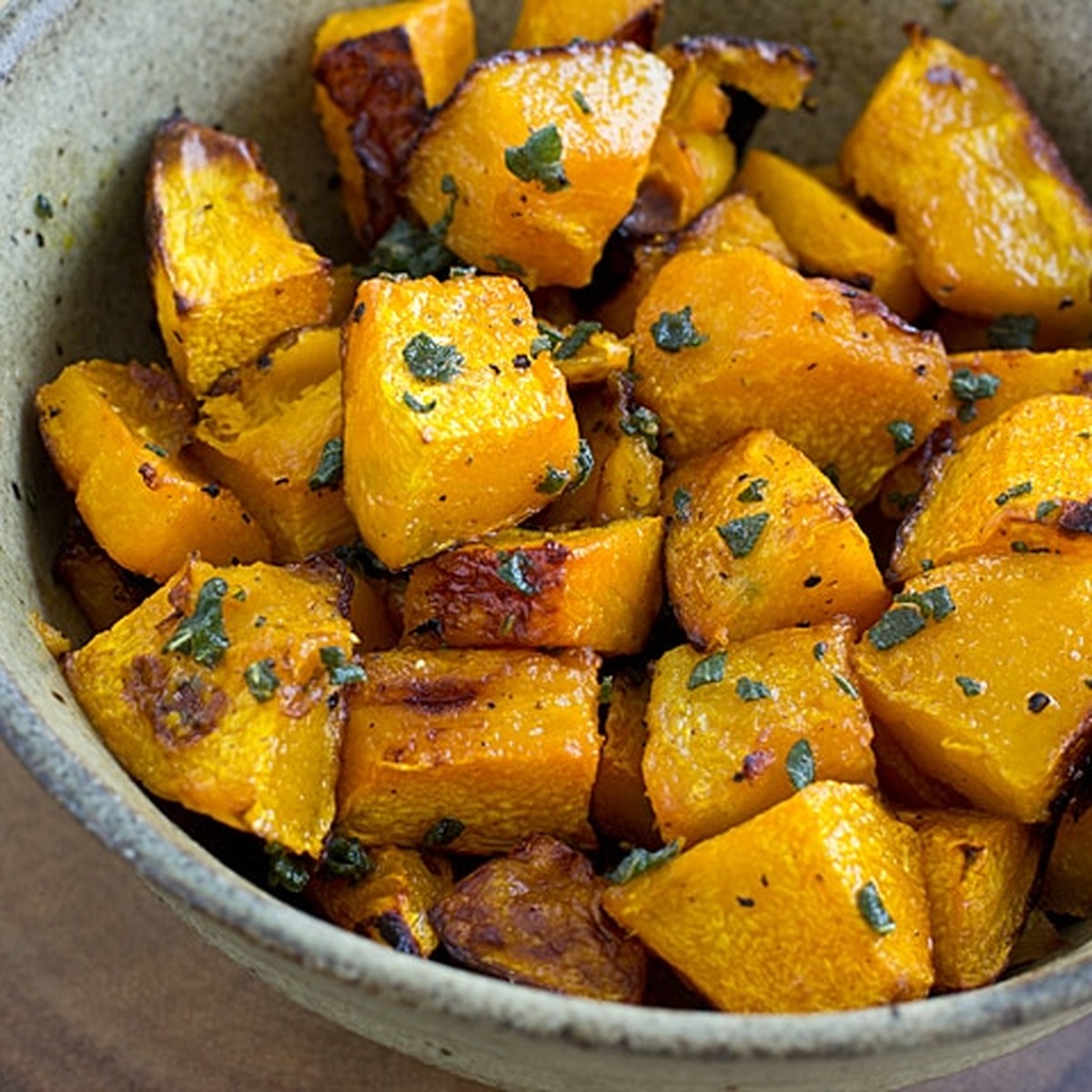 Roasted ambercup squash cubes tossed with brown butter and fresh sage in a stoneware bowl