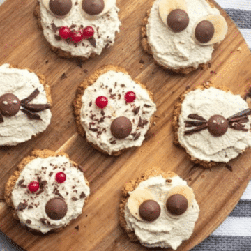 Spooky vegan Halloween cookies with cashew frosting on a wooden board