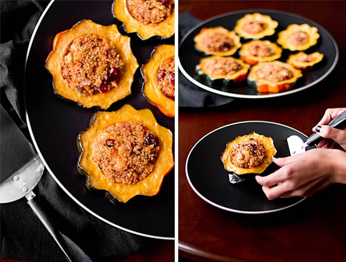 Stuffed acorn squash rings on a platter and one ring being lifted onto a plate with a spatula