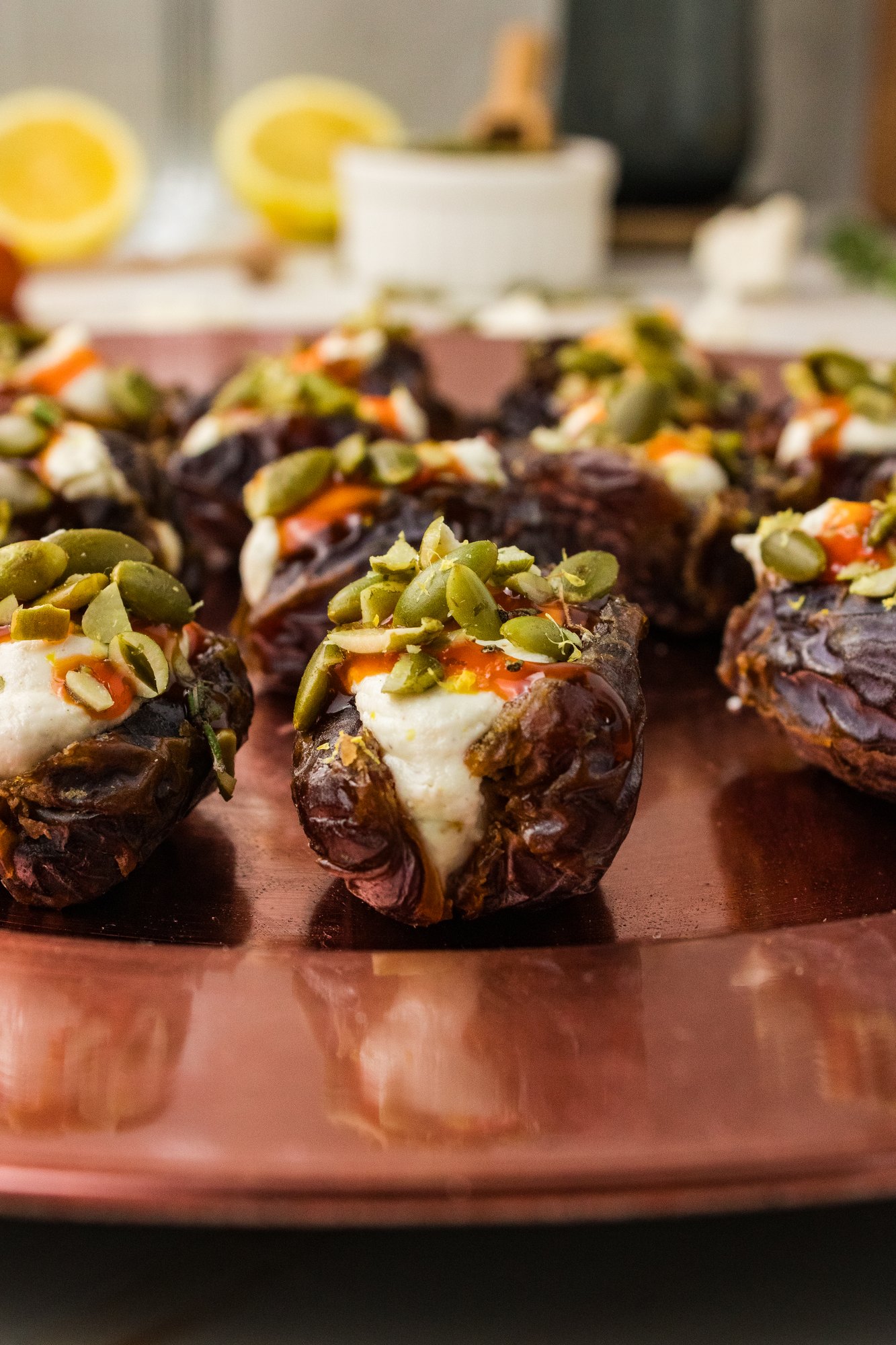 Platter of whipped feta stuffed dates with hot honey on a copper charger for a holiday party