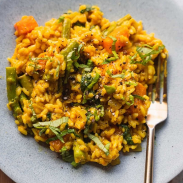 Vegan butternut squash risotto with asparagus and spinach on a grey plate