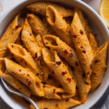 Bowl of creamy vegan pumpkin pasta topped with chili flakes