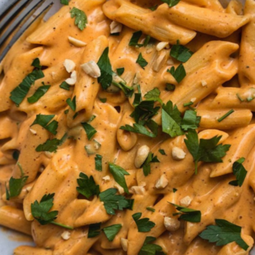 Bowl of vegan sweet potato pasta with creamy orange sauce and fresh parsley