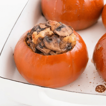 Vegetarian stuffed pumpkin filled with spinach, mushrooms and cheese in a white baking dish